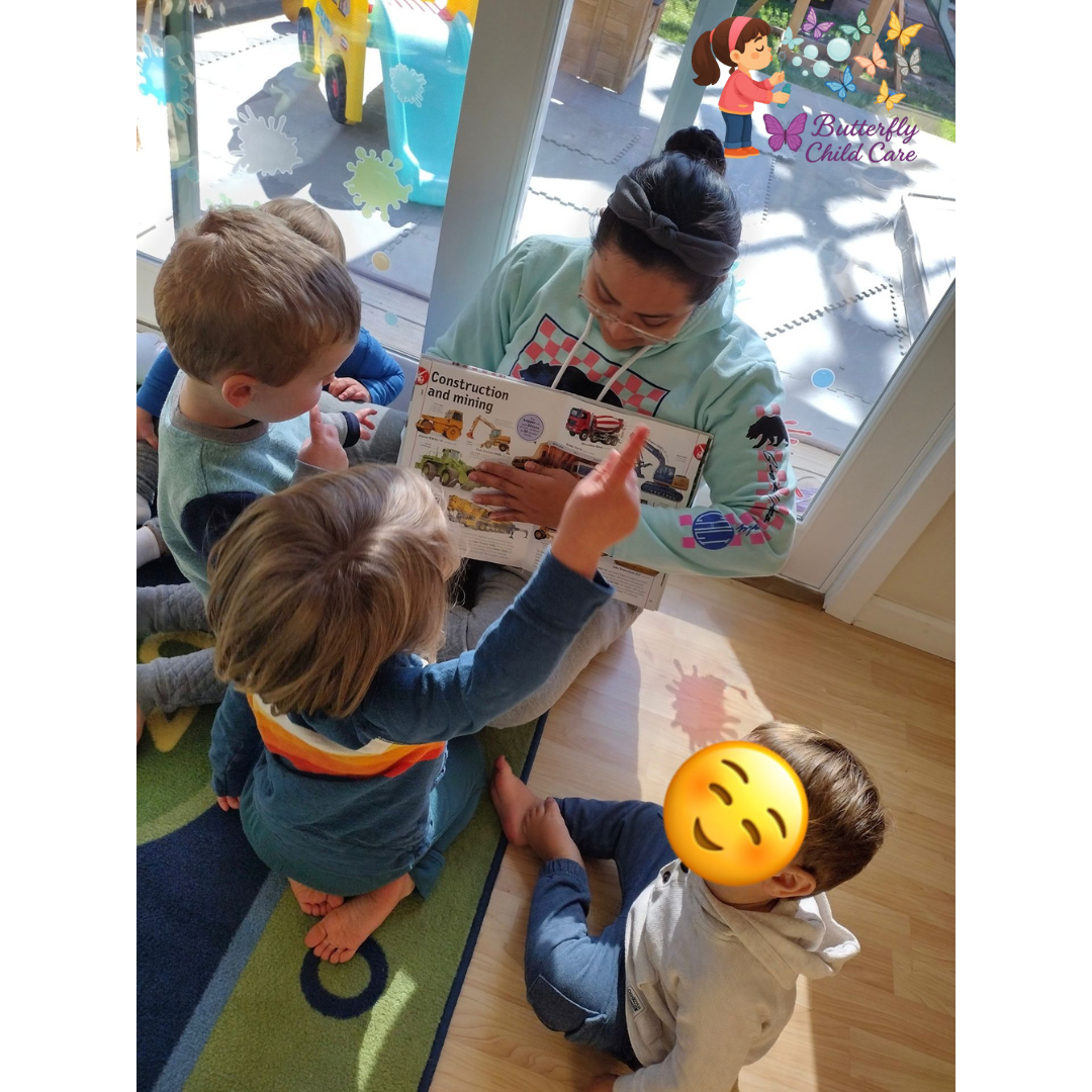 Teacher reading a picture book to toddlers during learning time at Butterfly Child Care